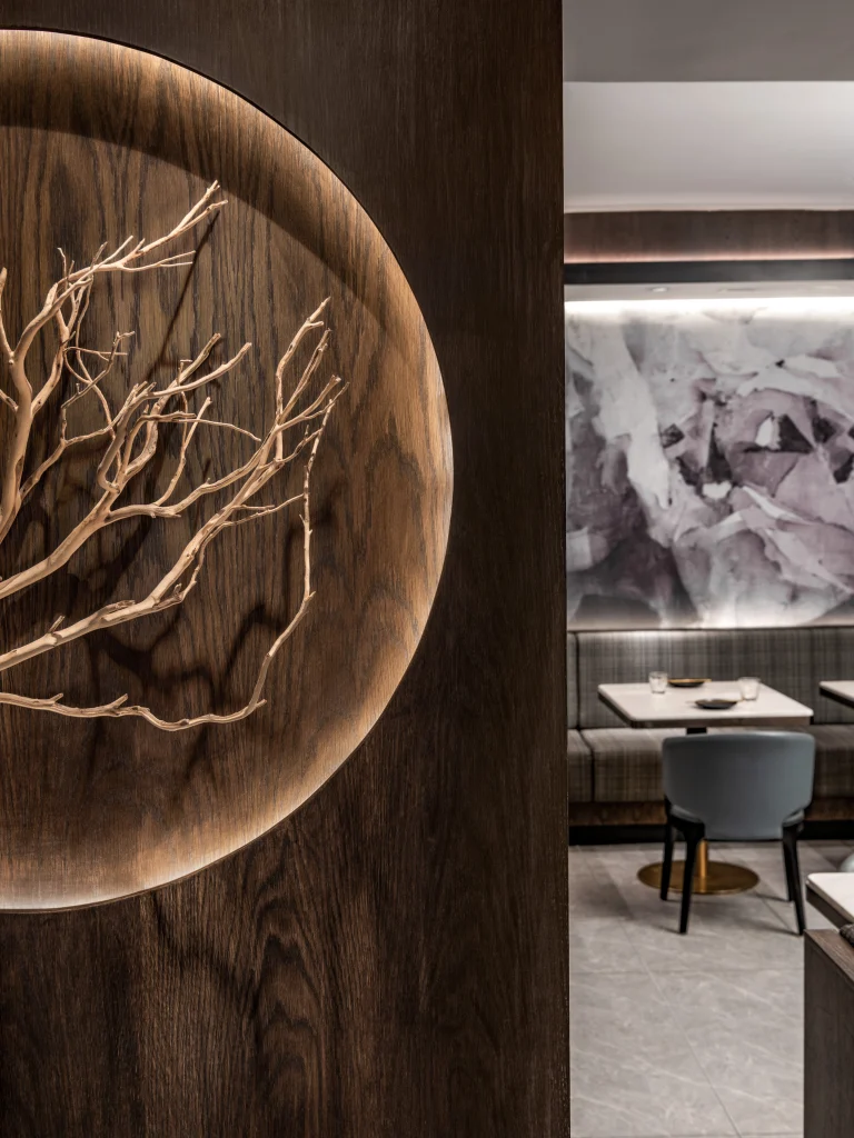 Interior Design - Circular wooden wall art featuring a tree branch design, illuminated for emphasis. Dexign Matter Studio