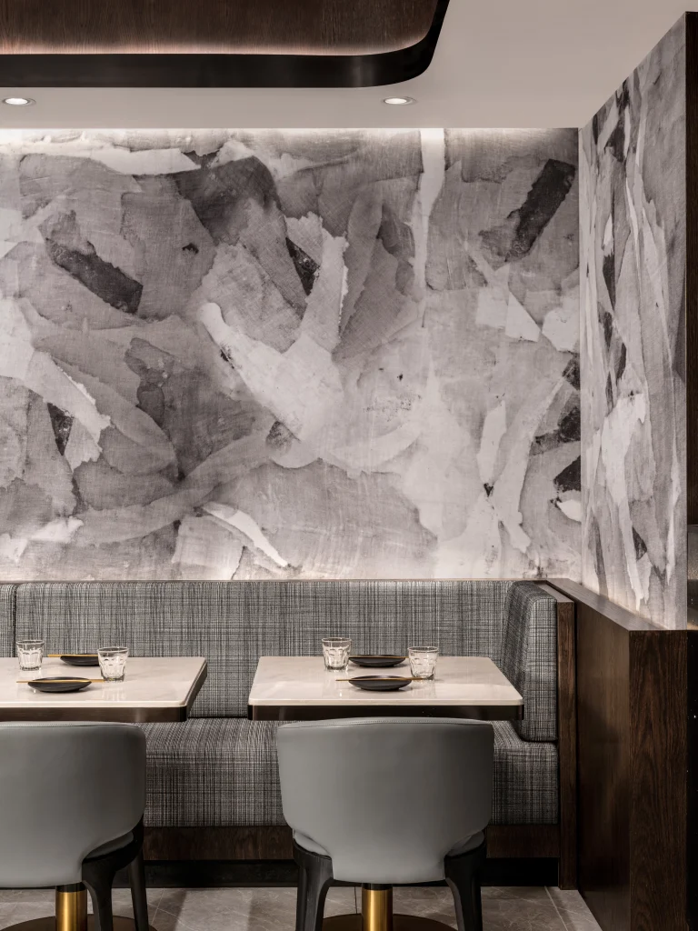 Interior Design - Interior view featuring gray textured wall art and modern seating arrangement in a dining area. Dexign Matter Studio