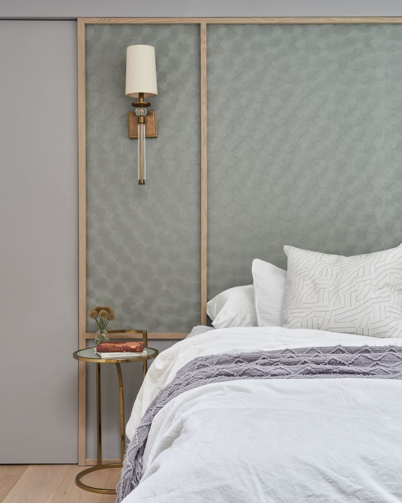 Interior Design - A modern bedroom featuring a textured wall, bedside table, and decorative pillows on the bed. Dexign Matter Studio
