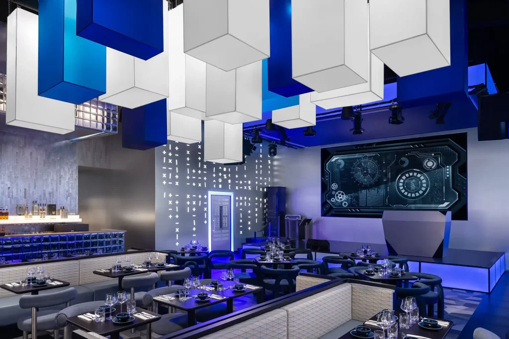 Interior Design - Interior view of a modern restaurant featuring geometric ceiling lights and a digital display. Dexign Matter Studio