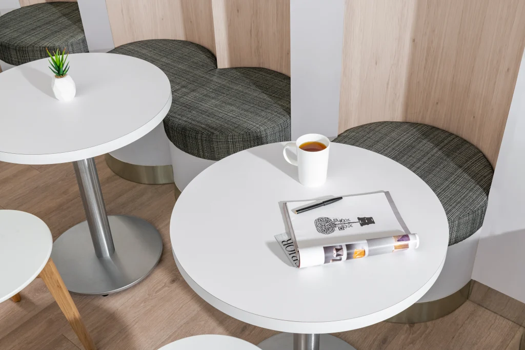 Interior Design - A white round table featuring a cup of tea, a magazine, and a pen in a modern interior setting. Dexign Matter Studio