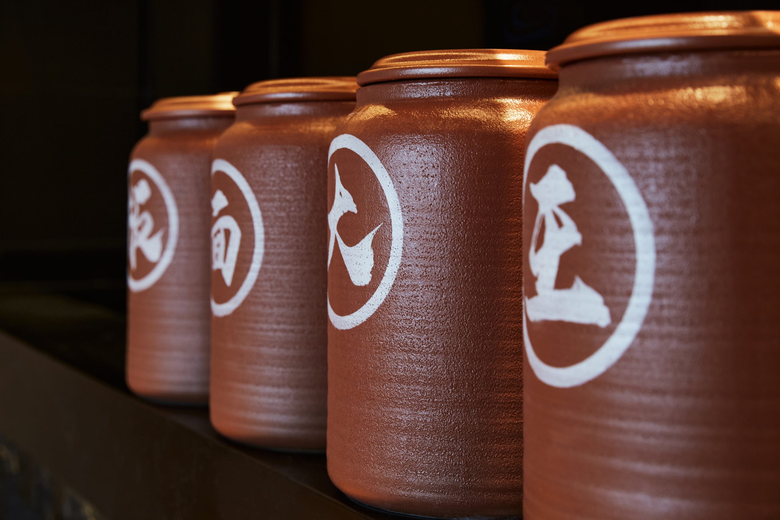 Interior Design - Row of ceramic storage jars featuring white symbols on a brown background. Dexign Matter Studio