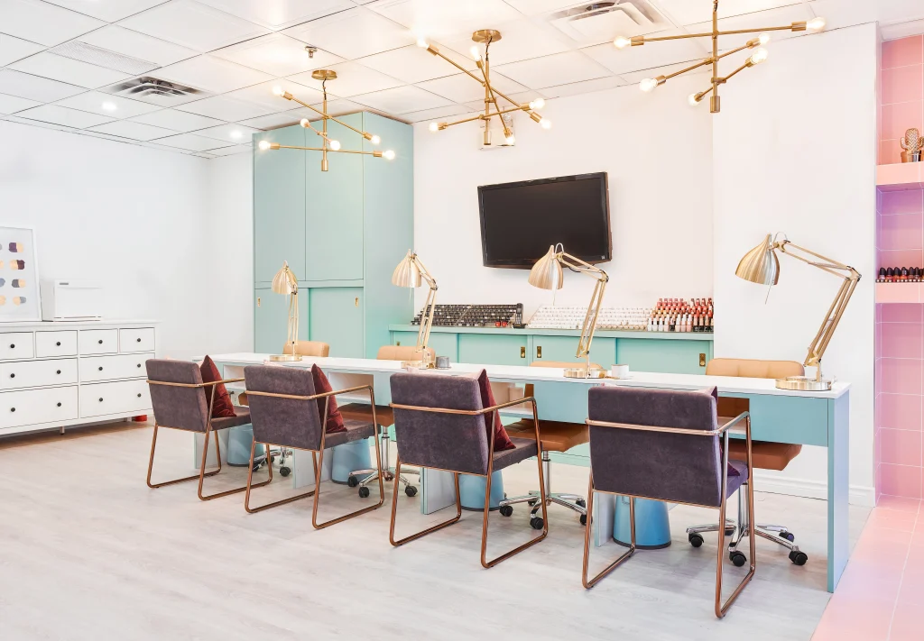 Interior Design - Interior view of a nail salon featuring multiple workstations with lamps and chairs. Dexign Matter Studio