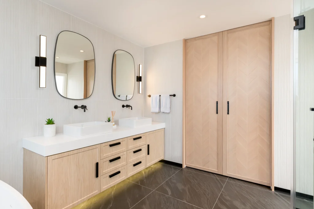 Interior Design - Contemporary master bathroom featuring dual sinks, mirrors, and wooden cabinetry. Dexign Matter Studio