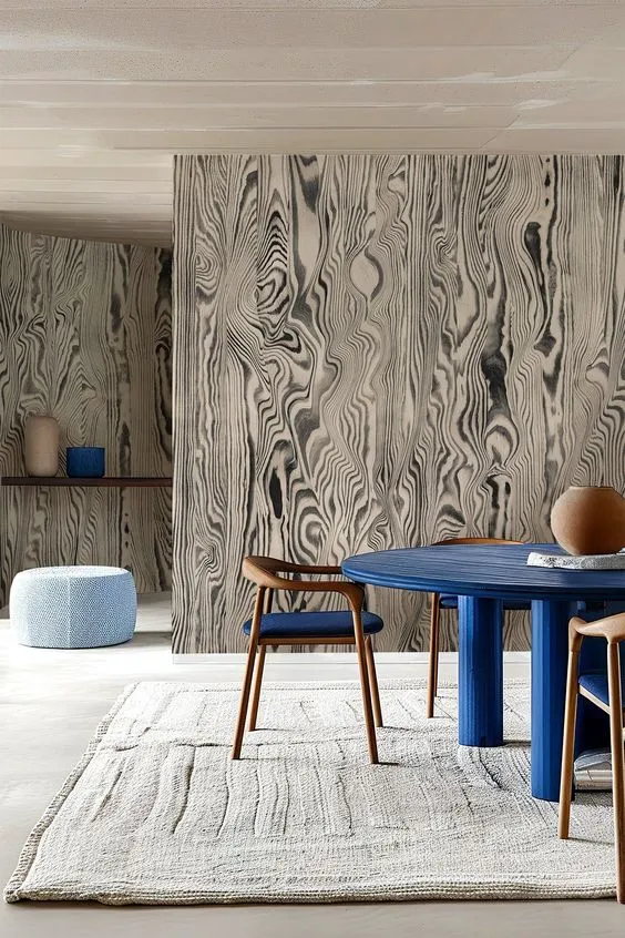 Interior Design - Interior space featuring a wood-patterned wall, a round blue table, and wooden chairs. Dexign Matter Studio