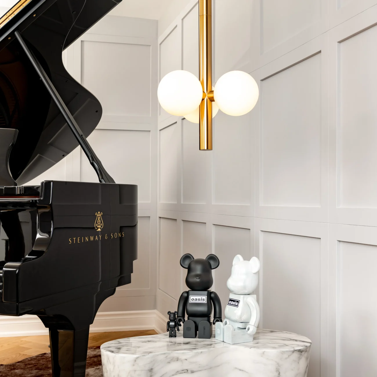 Interior Design - Steinway & Sons grand piano beside Bearbrick figures on a marble table. Dexign Matter Studio