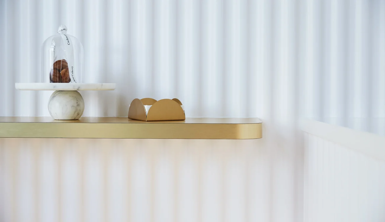 Interior Design - A decorative shelf featuring a cake stand with cookies and a small pastry box. Dexign Matter Studio