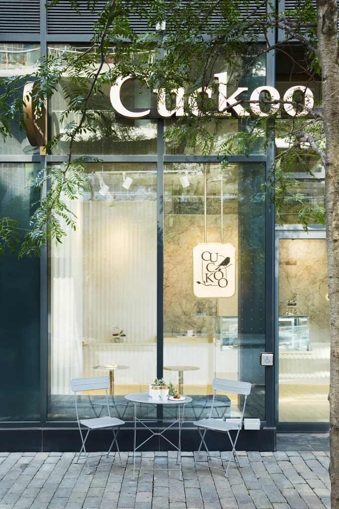 Interior Design - Exterior view of Cuckoo Bakery featuring a small table and chairs outside. Dexign Matter Studio
