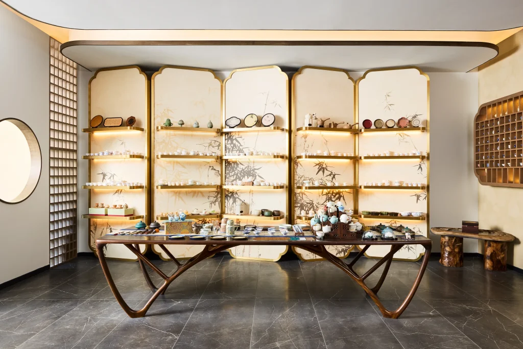 Interior Design - Interior view of a tea display featuring various tea products on shelves and a wooden table. Dexign Matter Studio