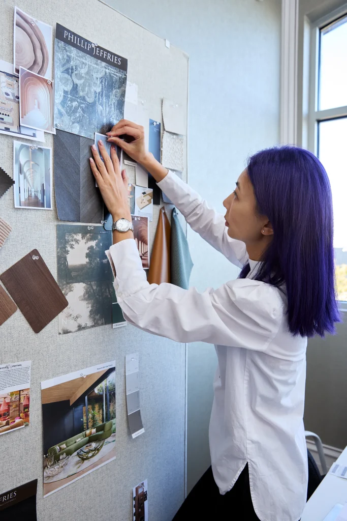 Interior Design - Interior designer arranging material samples on a pinboard in a studio setting. Dexign Matter Studio