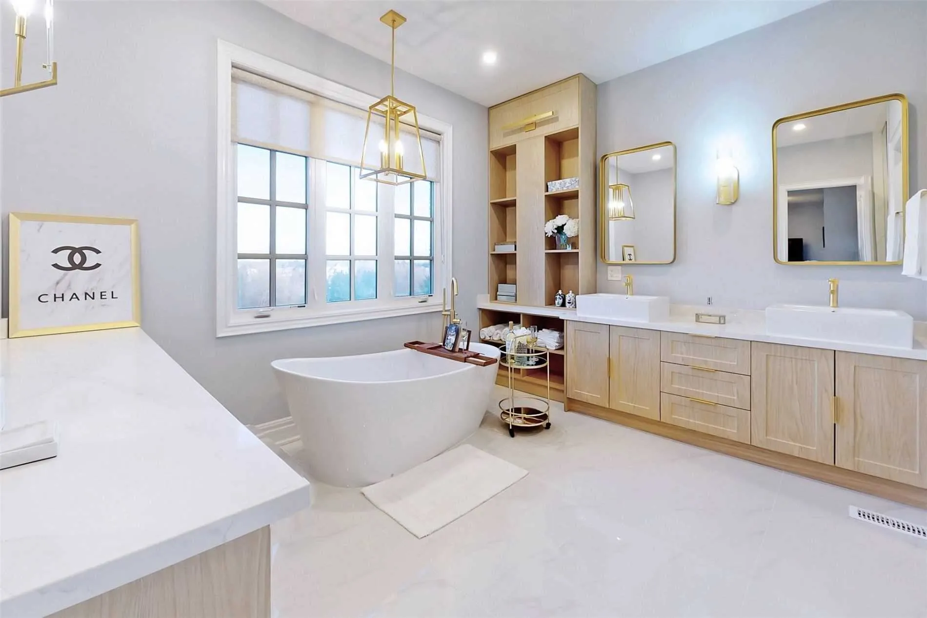 Interior Design - Contemporary bathroom featuring a freestanding tub, dual sinks, and Chanel branding on display. Dexign Matter Studio
