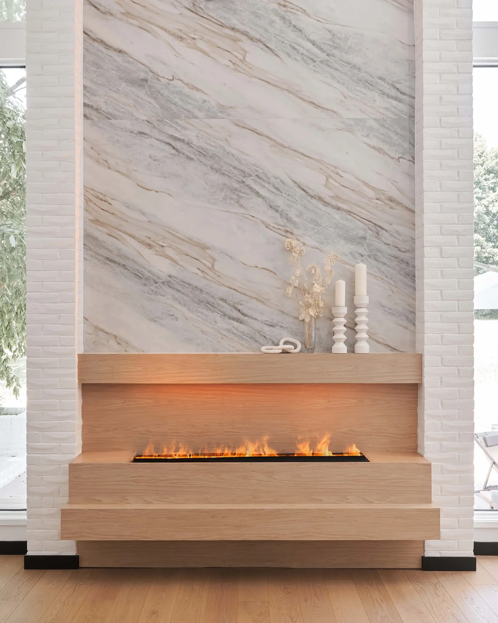 Interior Design - Contemporary fireplace with a marble wall and wooden mantel, featuring a flame display. Dexign Matter Studio