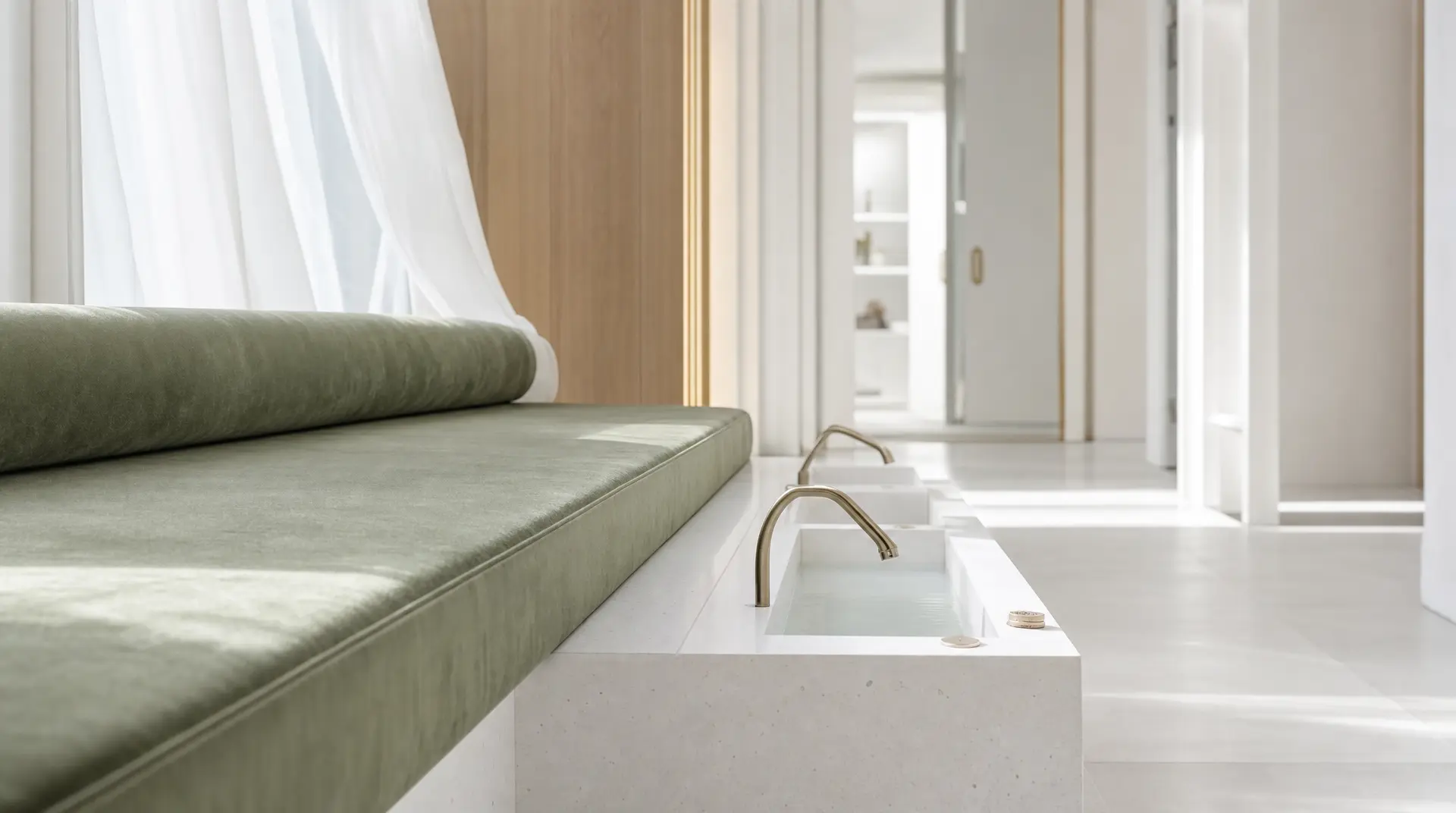 A modern bathroom features a built-in rectangular tub with a gold faucet, pale stone counters, and warm wood paneling, reflecting a spa like ensuite design and luxury medical spa design.