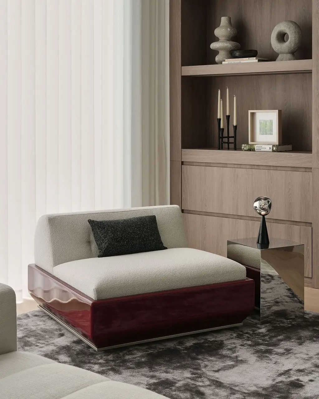Interior Design - A sculptural cream lounge chair with a dark pillow sits beside a mirrored side table in a calm neutral living room. Dexign Matter Studio